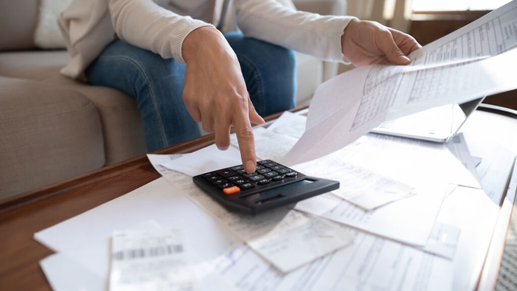 papers all over a desk and a calculator