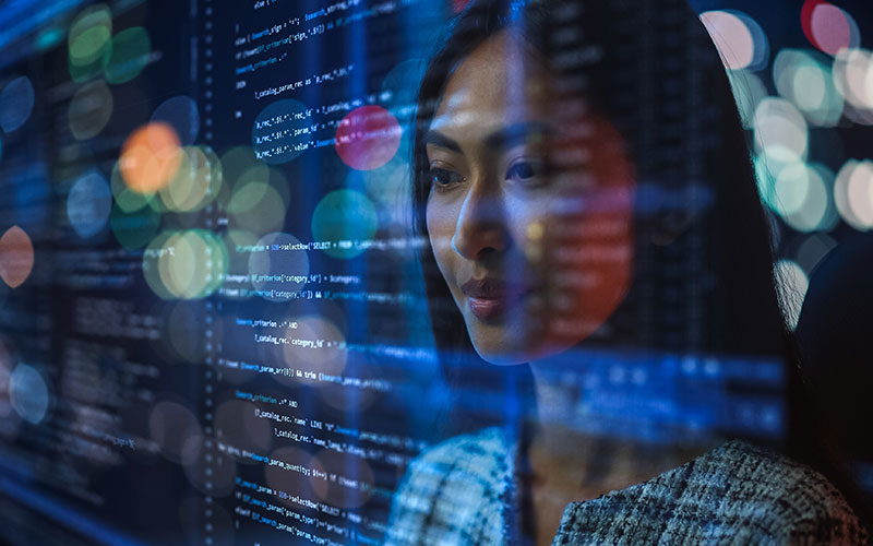 asian woman looking at computer code